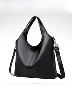Close-up of black lychee-grain leather tote bag with silver metal hardware and strap