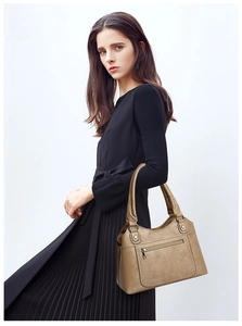 Detail of khaki washed leather tote with metal rivets and reinforced handle stitching