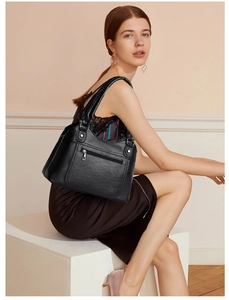 Close-up of black washed leather tote bag with functional zipper pocket and lychee texture