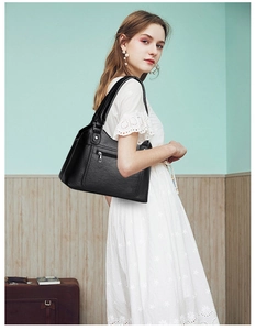 Close-up of black PU leather shoulder bag featuring classic lychee texture and metal zipper