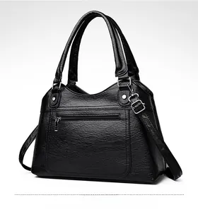 Side view of black lychee grain faux leather tote bag with silver zippers and straps
