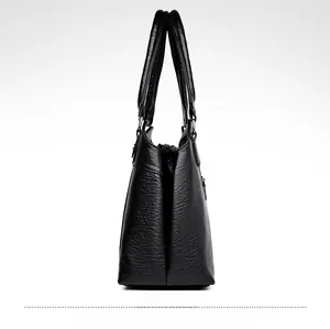 Side view of large black PU leather tote bag showing soft natural pleated texture and handles