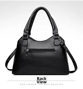 Back view of black faux leather tote bag showing rear zipper pocket and strap