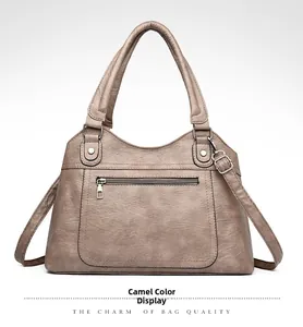 Detail of the camel brown faux leather tote with textured finish and front zip pocket