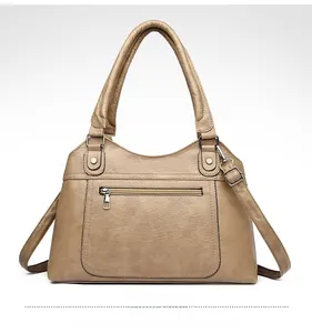 Detail of khaki washed leather tote bag showing front zipper pocket and silver hardware