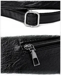 Detail of adjustable shoulder strap and smooth silver metal zipper on black PU tote bag