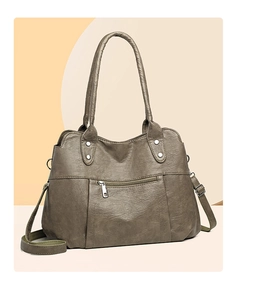 Close-up of vintage soft leather tote bag showing side metal ring and woven strap detail