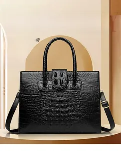 Detail of black crocodile texture tote with gold hardware and stylish round handles