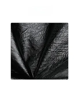 Close-up of soft black faux leather featuring a detailed lychee texture and matte finish