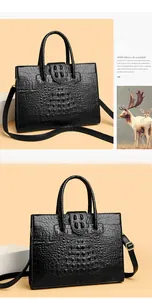 Detail of black crocodile texture handbag with gold hardware and removable shoulder strap