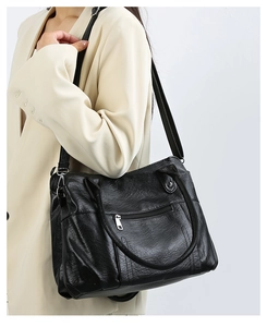 Détail du sac cabas en similicuir noir avec poche zippée avant et texture grainée