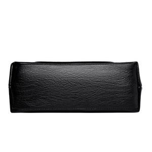 Bottom view of large black faux leather shoulder bag with pebbled texture and neat stitching