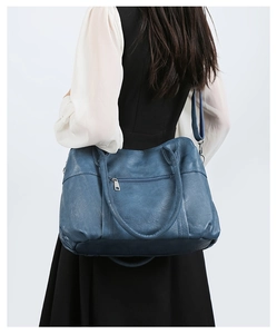 Blue soft leather tote bag with front zipper pocket shown on model for casual styling