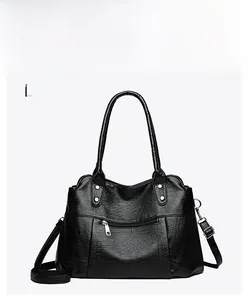 Détails de la texture en cuir noir et des rivets argentés sur ce sac à bandoulière vintage