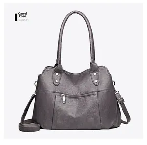 Detail showing the adjustable shoulder strap and smooth camel faux leather texture