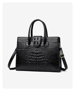 Detail shot of the black crocodile pattern texture and golden hardware on the tote bag