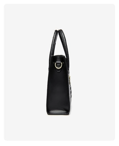 Detail showing crocodile texture handle and gold D-ring on black faux leather handbag