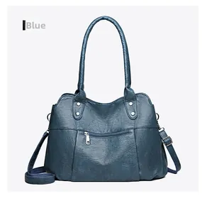 Détail du sac à main en cuir souple bleu avec fermetures éclair argentées et bandoulière