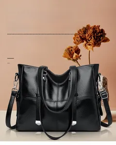 Détail du sac cabas en cuir noir avec boucles métalliques et texture grainée