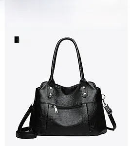 Detailed front view of black textured faux leather tote bag with silver studs