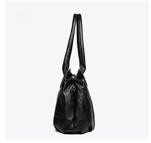 Vue latérale du sac fourre-tout noir en similicuir avec base large et silhouette robuste