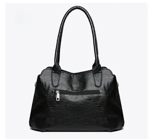 Détail du dos d'un cabas en cuir noir à motif litchi avec poche arrière zippée argentée