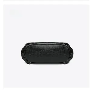 Détail du fond d'un sac à main en cuir grainé noir avec coutures précises