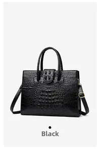 Detail of black crocodile texture women tote bag with dual handles and gold hardware