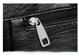 Gros plan d'une fermeture éclair en métal argenté sur un sac en cuir noir grainé
