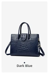 Close-up of deep blue crocodile pattern embossed leather handbag with golden metal hardware
