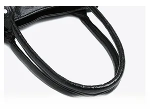 Détail de la poignée en cuir rembourrée sur un sac à main vintage noir élégant