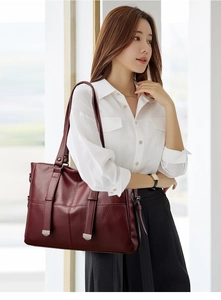 Détail du sac cabas en cuir bordeaux montrant la texture fine et les accents métalliques