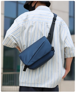 Blue waterproof crossbody bag with Move to Future print shown on a male model outdoors