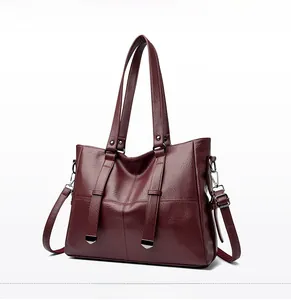 Détail du sac cabas bordeaux avec texture cuir litchi et finitions métalliques