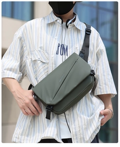 Close-up of green water-resistant messenger bag with adjustable strap and buckle