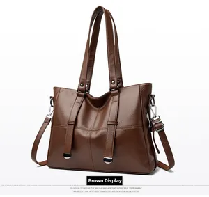 Détail d'un sac cabas en cuir marron avec garniture argentée et bandoulière réglable