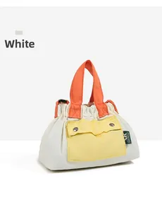 Detail of a nylon crossbody bag with orange handles and a bright yellow front pocket