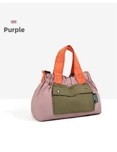 Detail of multi-color nylon handbag showing purple body and contrast olive pocket