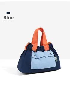 Detail of color-block nylon crossbody bag with blue, orange handles and front pocket