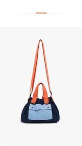 Detail of nylon crossbody bag with contrast orange handles and blue flap pocket