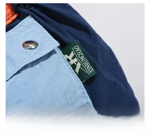 Close-up of colorful nylon bag featuring a silver metal snap and premium woven logo tag