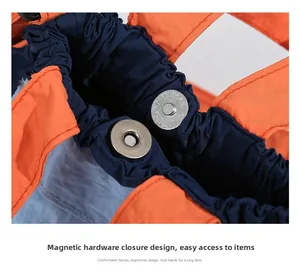 Close-up of contrast nylon bag showing metal magnetic closure and orange handle detail