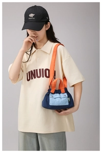 Detail of color-blocked nylon crossbody bag featuring blue fabric and orange straps