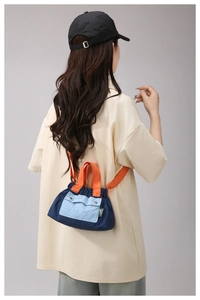 Detail of color-block nylon crossbody bag shown in a real-life casual outfit style