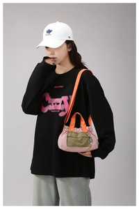 Close-up of contrast color nylon crossbody bag with pink body and green pockets