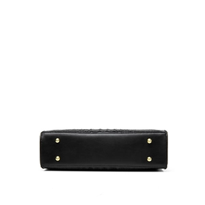 Bottom view of black faux crocodile tote bag featuring four protective gold metal feet