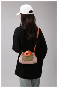 Macro shot of tricolor nylon crossbody bag with drawstring closure and green front pocket