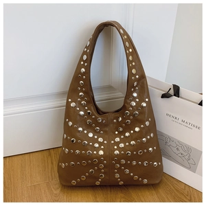 Detail der braunen Hobo-Tasche aus Leder mit dekorativen Nieten im Schmetterlingsmuster