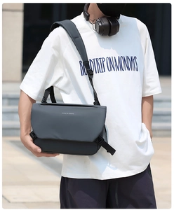 Detailed view of gray waterproof messenger bag with move to future print on outdoor model