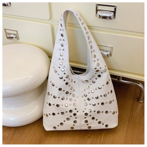 Detail der weißen Hobo-Tasche aus Leder mit silbernen Rundnieten und Schulterriemen